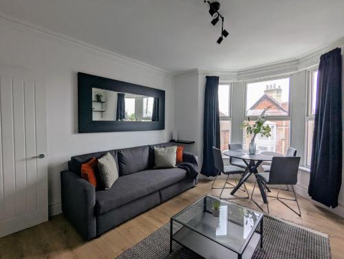 a living room with a couch and a table at Conegra Road Apartments in High Wycombe