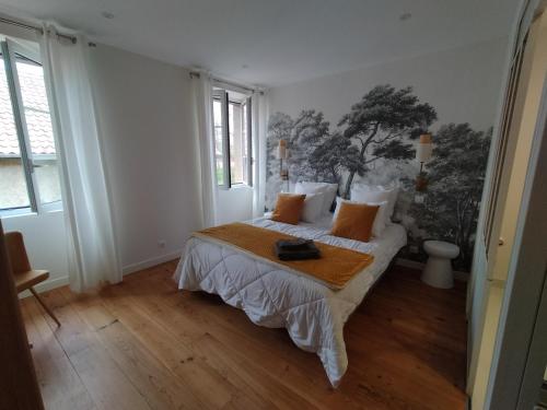 a bedroom with a bed with orange pillows at chambres d'hôtes numéro 2 Le Bedat côté jardin in Labatut