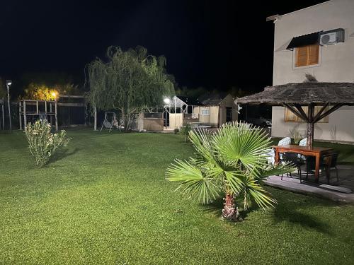 a backyard at night with a table and a palm tree at BRISAS DEL VALLE San Rafael in Valle Grande