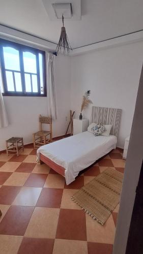 a bedroom with a bed and a checkered floor at Buena vista morroco GUEST HOUSE in Tamraght Ouzdar