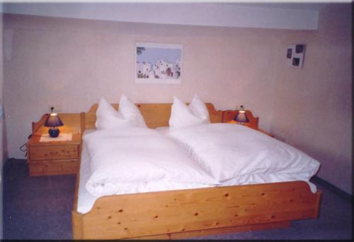 a bedroom with a bed with white sheets and two lamps at Lärchenhof in Leutasch