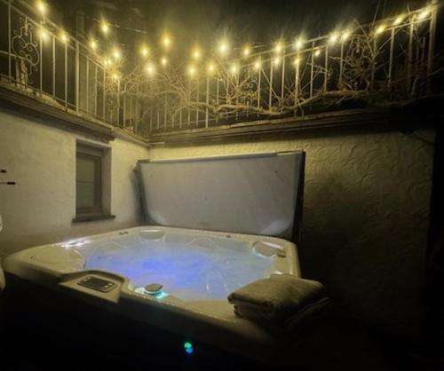 a bathroom with a tub with lights on a balcony at Zen Retreat met jacuzzi in Grez-Doiceau