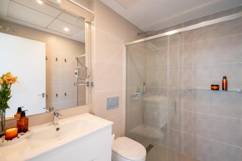 une salle de bains avec douche, toilettes et lavabo dans l'établissement BENIDORM Amber Stay, à Finestrat