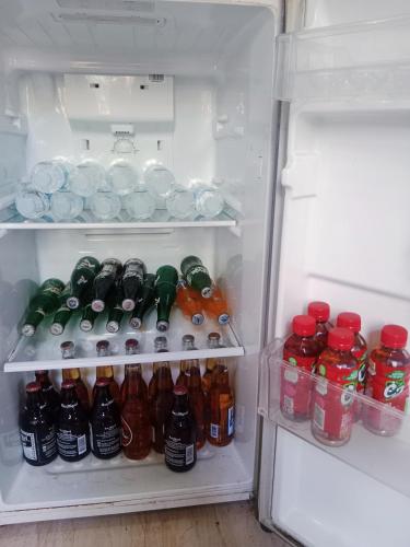 an open refrigerator filled with bottles and drinks at DJL Summer House - Bantayan Island in Patao