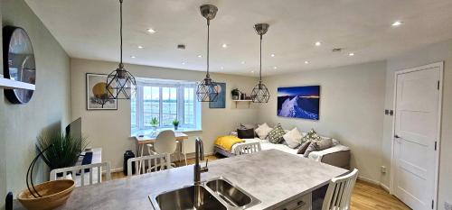 a kitchen and living room with a table and a couch at Riverview Apartments by Switchback Stays in Cardiff