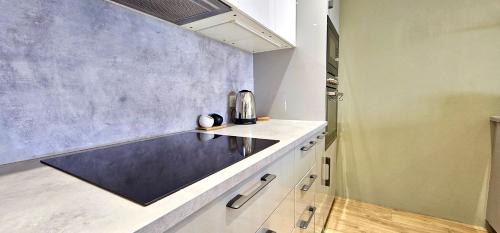 a kitchen with a counter top and a wall at Riverview Apartments by Switchback Stays in Cardiff