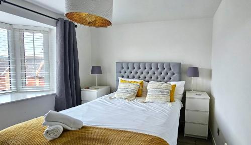 a bedroom with a large bed with yellow pillows at Riverview Apartments by Switchback Stays in Cardiff