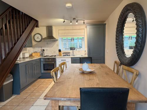a kitchen with a wooden table and a dining room at Standlow Farm in Kniveton