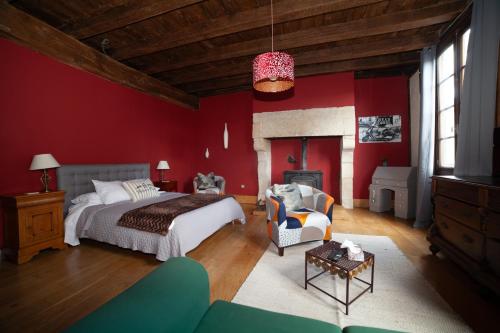 a bedroom with a bed and a red wall at Pont Vieux Chambres et Gites in Confolens