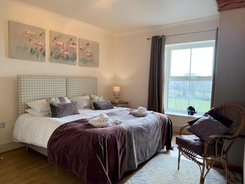 a bedroom with a bed with a window and a chair at Standlow Farm in Kniveton