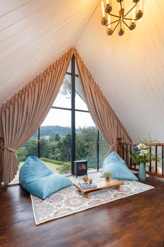 a living room with blue pillows and a table at The Chapter in Nuwara Eliya