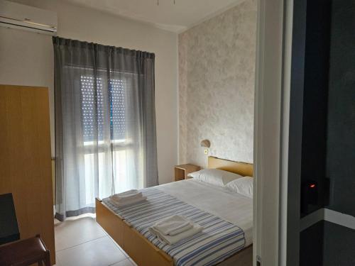 a small bedroom with a bed and a window at PAPER MOON in Bellaria-Igea Marina