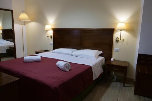 a bedroom with a large bed with two towels on it at Hotel Elios Tao in Taormina
