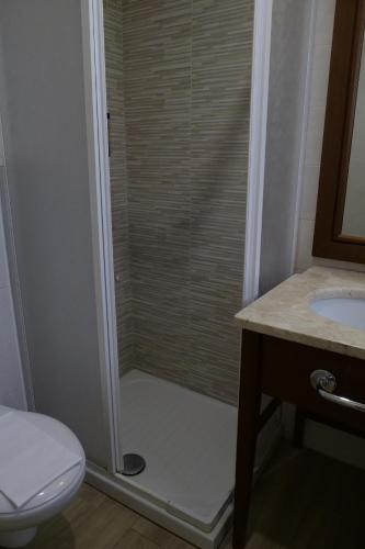 a bathroom with a shower with a toilet and a sink at Hotel Elios Tao in Taormina