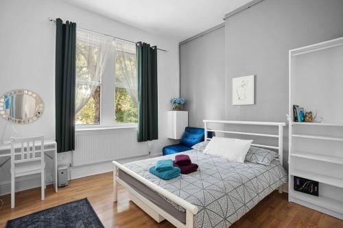 a bedroom with a white bed and a blue chair at Modern Spacious Rooms 10 Minutes from Big Ben in London