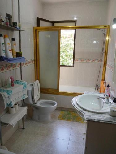a bathroom with a toilet and a sink and a window at Cuarto Privado Doble en Toledo in Toledo