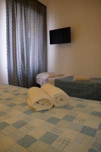a bedroom with two towels laying on a bed at Hotel Elios Tao in Taormina