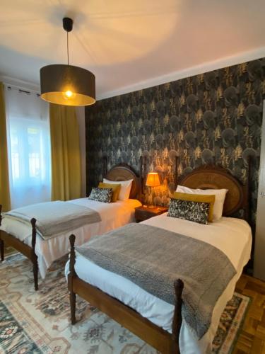 a bedroom with two beds and a fireplace at Pátio da Villa - Coruche Boutique Guest House in Coruche