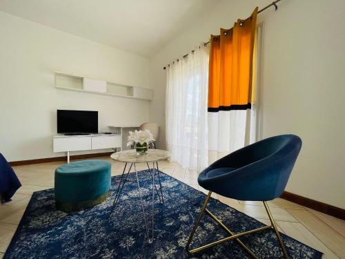 ein Wohnzimmer mit einem blauen Sessel und einem Fernseher in der Unterkunft Tia Vahine in Ivato
