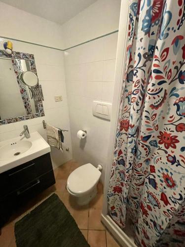 a bathroom with a toilet and a shower curtain at Cappuccino Apartment Sorrento in Sorrento
