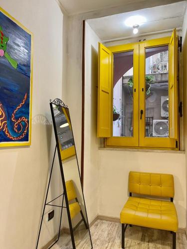 a yellow cabinet and a chair in a room at Cappuccino Apartment Sorrento in Sorrento