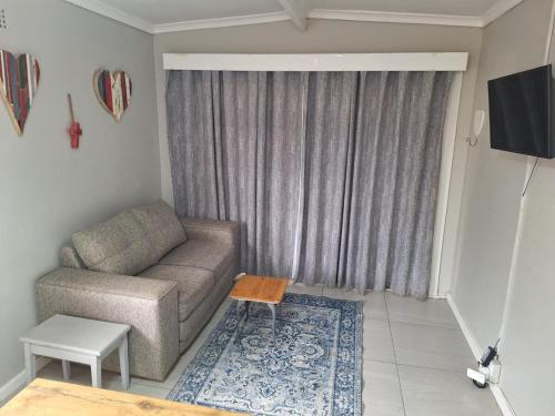 a living room with a couch and a table at Hearts Cottage in Kimberley