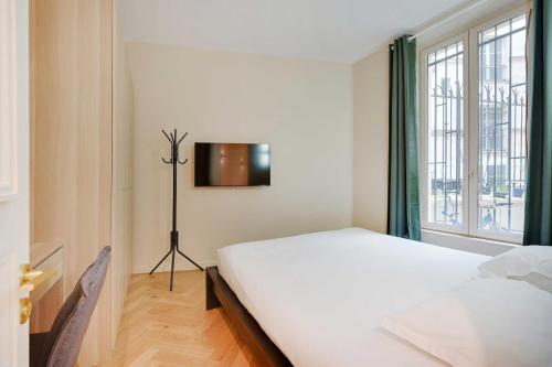 une chambre avec un lit blanc et une fenêtre dans l'établissement Spacious apartment - 3BR-8P - Ternes, à Paris