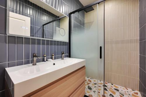 La salle de bains est pourvue d'un lavabo blanc et d'une douche en verre. dans l'établissement Spacious apartment - 3BR-8P - Ternes, à Paris