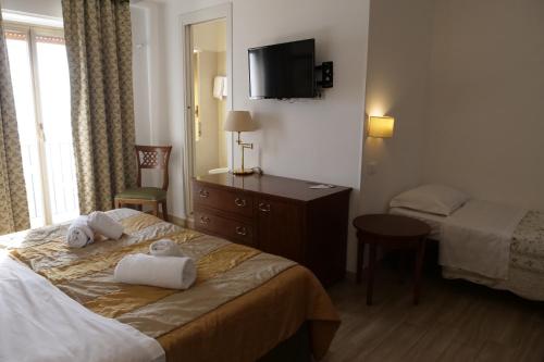 a hotel room with two towels on a bed at Hotel Elios Tao in Taormina