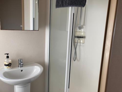 ein Badezimmer mit Waschbecken und Dusche mit Spiegel in der Unterkunft Tattershall Lakes Luxury Hot Tub Breaks in Tattershall