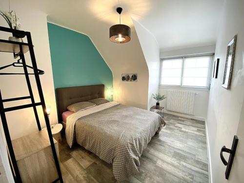 une chambre avec un lit et un mur bleu dans l'établissement Maison Renovée Plomelin - Countryside and Beaches, à Plomelin