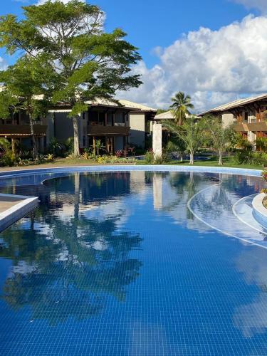 a large swimming pool in front of a house at Itacimirim Bioflora - Térreo 2 Suítes in Itacimirim