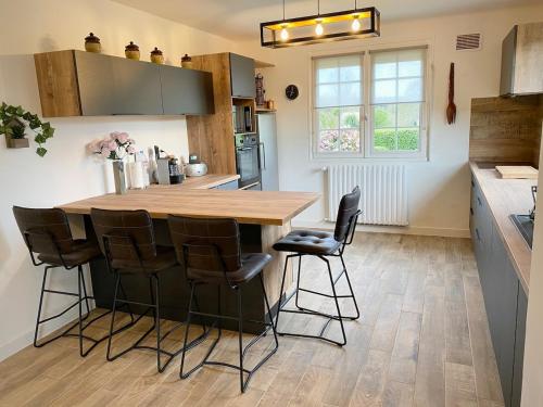 - une cuisine avec une table en bois et des tabourets de bar dans l'établissement Maison Renovée Plomelin - Countryside and Beaches, à Plomelin