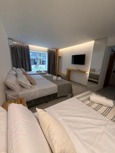 a hotel room with two beds and a television at Los Cardos Lodge & Glamping in Malargüe