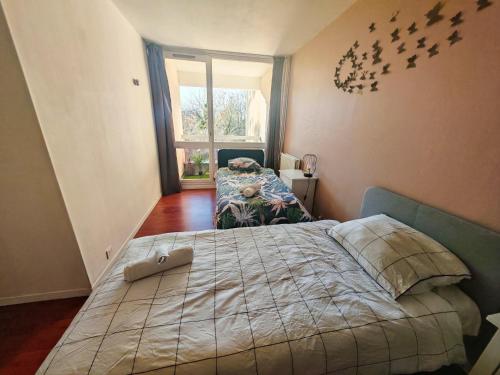a bedroom with a bed with birds on the wall at T3 COSY petit balcon 5mins France miniature in Élancourt