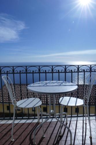a table and chairs on a balcony with the ocean at Hotel Elios Tao in Taormina