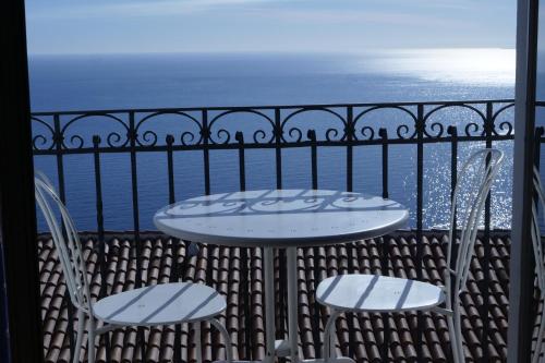 a table and two chairs on a balcony with the ocean at Hotel Elios Tao in Taormina