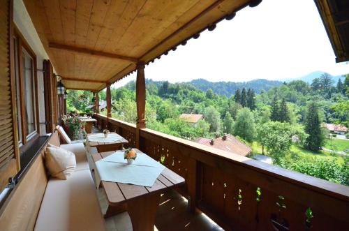 a balcony with tables and a view of the mountains at Gästehaus Sonnenbichl in Fischbachau