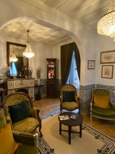 a living room with chairs and a table and a chandelier at Pátio da Villa - Coruche Boutique Guest House in Coruche