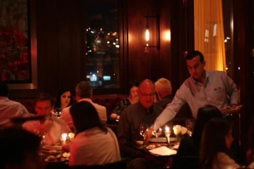 a chef serving people in a restaurant at Hotel Casa Higueras in Valparaíso