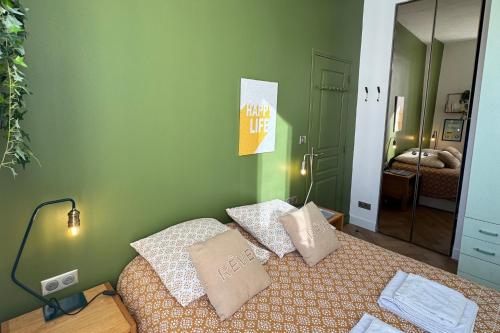 - une chambre avec un lit doté d'oreillers et d'un miroir dans l'établissement Cosy Cocoon Place Massena, à Nice