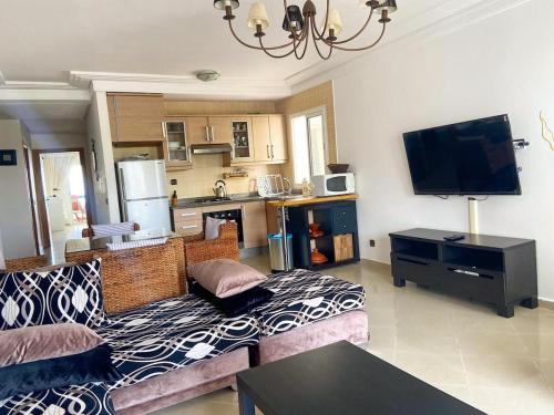 a living room with a couch and a kitchen at Golf & sea view appartement in Asilah Marina Golf in Asilah