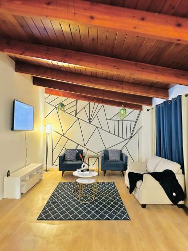 a living room with a couch and a table at P&N Suites - DELUXE QUEEN ROOM- LONDON in Edmonton