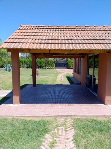 a pavilion with a roof on top of a field at La Vieja Finca in Ciudad Lujan de Cuyo