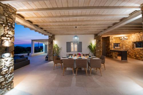 a dining room and living room with a table and chairs at Cocos Villa in Super Paradise Beach