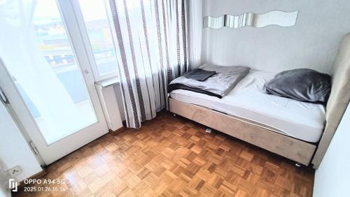 a small bed in a room next to a window at FMI1, Apartments in Eschborn