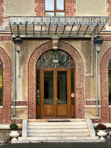 - une entrée pour un bâtiment en briques avec une porte en bois dans l'établissement Chambre au Château, à Chaumes-en-Brie