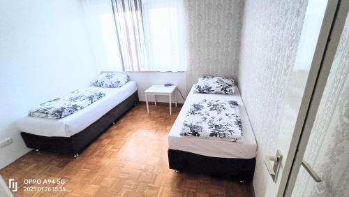 two beds in a small room with a window at FMI1, Apartments in Eschborn