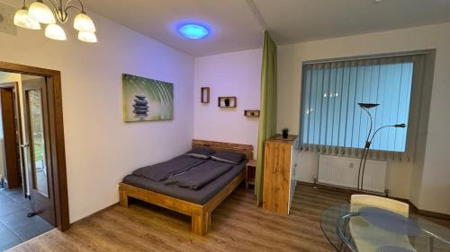 a bedroom with a bed and a glass table at Ruhiges Apartment mit guter Verkehrsanbindung in Gumpoldskirchen
