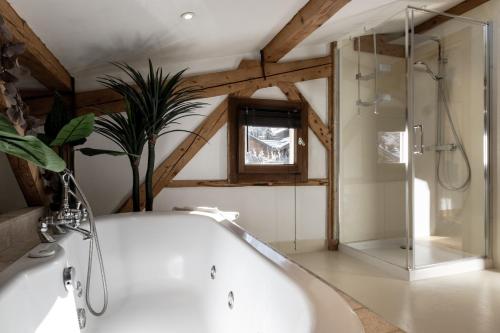 a bathroom with a white tub and a shower at Chalet Des Grands Vanays in Les Houches